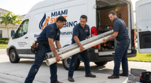 Miami Swift Plumbing technicians loading pipe into their service van